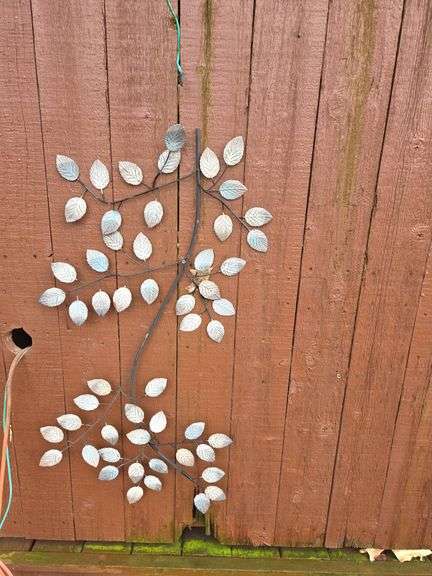 Hanging Metal Wall Art with Leaf Motif outside