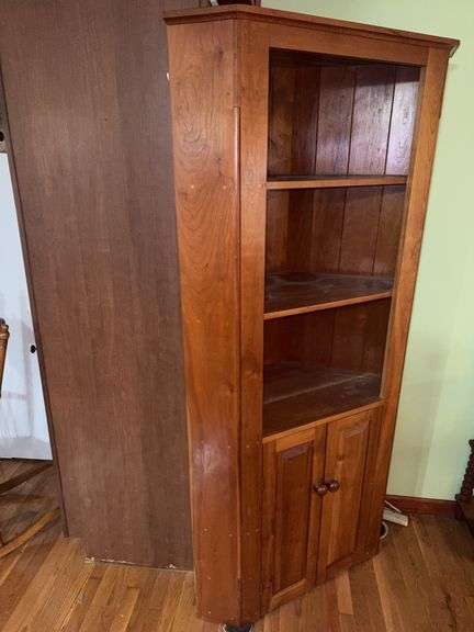 Wooden corner cabinet with display shelves and a lower storage cupboard