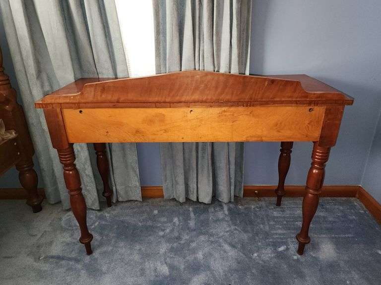 Vintage wooden side table with double drawers and turned legs.
