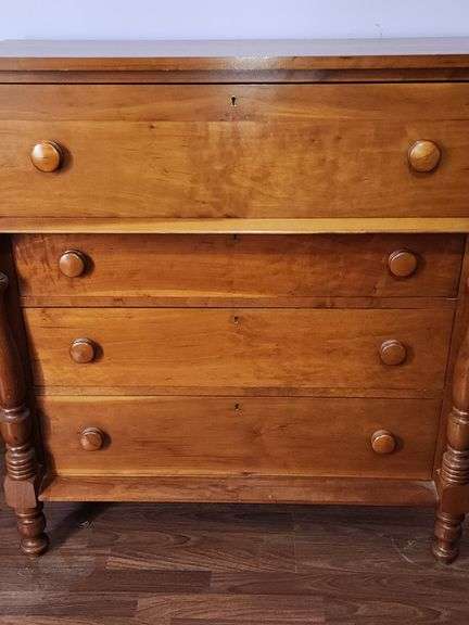 Wood chest of drawers with turned legs.