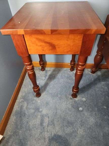 Vintage cherry wood nightstand with a single drawer and turned legs.