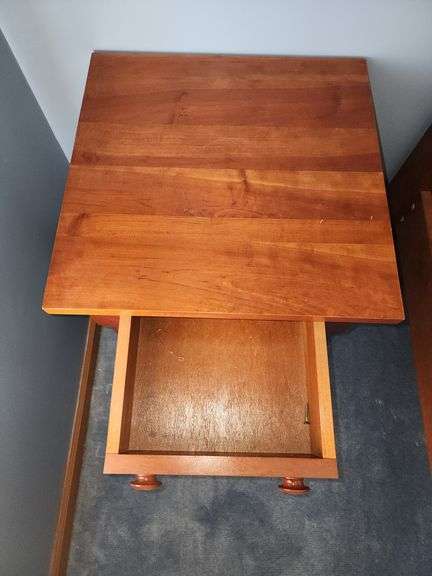 Vintage cherry wood nightstand with a single drawer and turned legs.