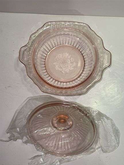 Pink depression glass serving bowl with a lid.