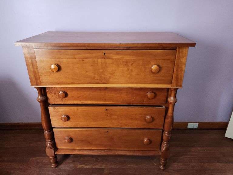 Wood chest of drawers with turned legs.