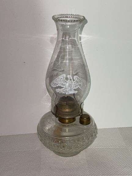 Clear glass oil lamp with chimney that has a Eagle on it