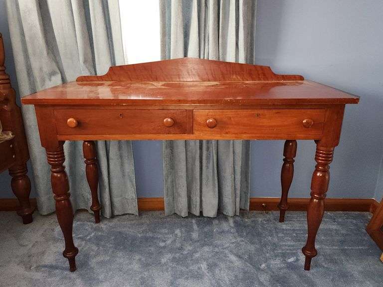 Vintage wooden side table with double drawers and turned legs.