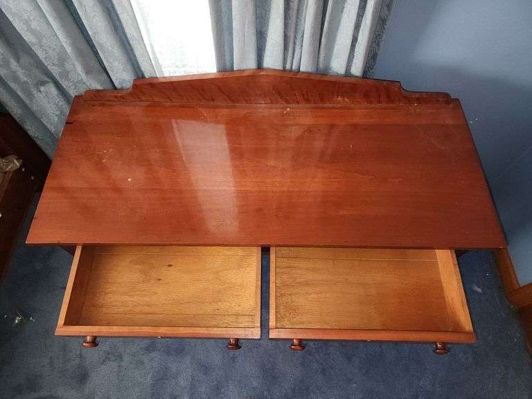 Vintage wooden side table with double drawers and turned legs.