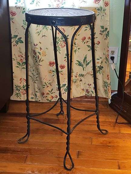 Vintage ice cream parlor stool with a twisted metal base and a round wooden seat.