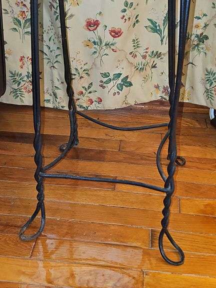 Vintage ice cream parlor stool with a twisted metal base and a round wooden seat.