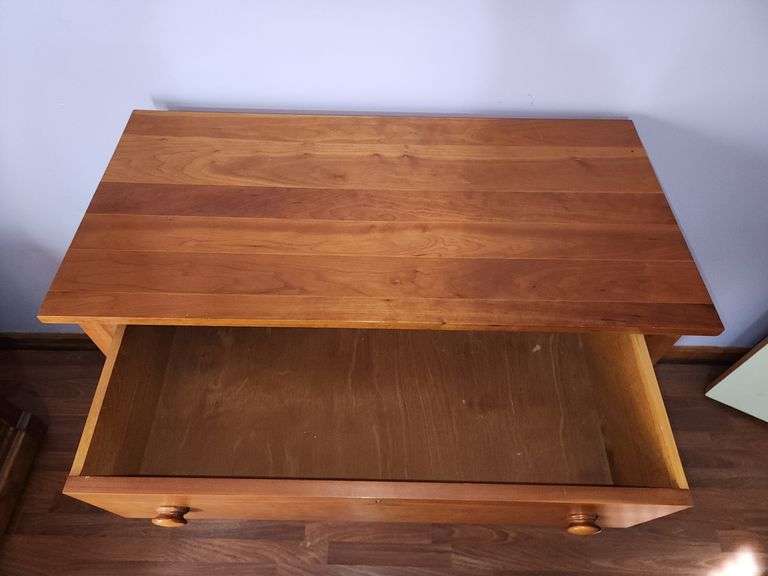 Wood chest of drawers with turned legs.