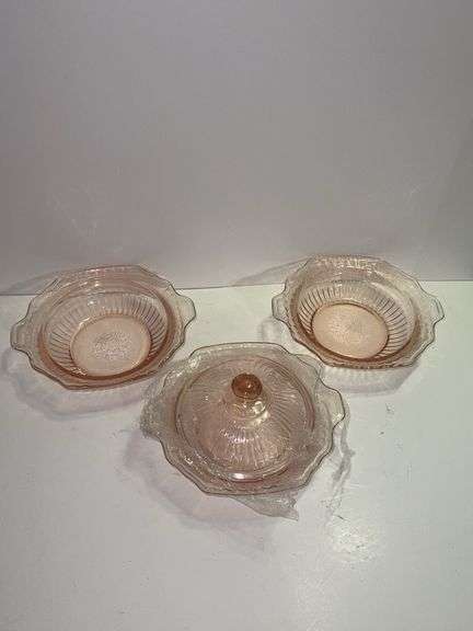 Pink depression glass serving bowl with a lid.