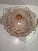 Pink depression glass serving bowl with a lid.