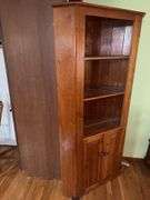 Wooden corner cabinet with display shelves and a lower storage cupboard