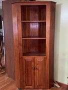 Wooden corner cabinet with display shelves and a lower storage cupboard