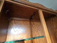 Solid oak gun cabinet with glass doors and a lower storage area with drawers