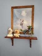 Framed print of Jesus, musical figurine, praying hands, & shelf.