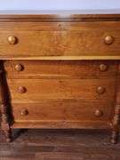 Wood chest of drawers with turned legs.