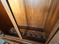 Solid oak gun cabinet with glass doors and a lower storage area with drawers