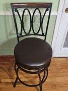 2 Black metal swivel bar stool with a dark brown cushioned seat.