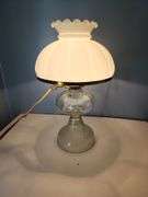 Vintage oil lamp witg milk glass lamp shade with a ruffled edge.