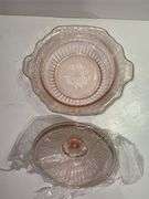 Pink depression glass serving bowl with a lid.