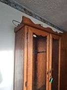 Solid oak gun cabinet with glass doors and a lower storage area with drawers