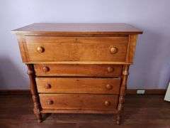 Wood chest of drawers with turned legs.