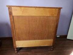 Wood chest of drawers with turned legs.