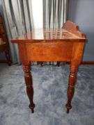 Vintage wooden side table with double drawers and turned legs.
