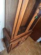 Solid oak gun cabinet with glass doors and a lower storage area with drawers