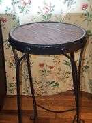 Vintage ice cream parlor stool with a twisted metal base and a round wooden seat.