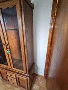 Solid oak gun cabinet with glass doors and a lower storage area with drawers