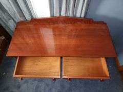 Vintage wooden side table with double drawers and turned legs.