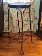 Vintage ice cream parlor stool with a twisted metal base and a round wooden seat.