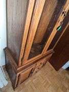 Solid oak gun cabinet with glass doors and a lower storage area with drawers