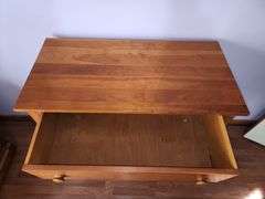 Wood chest of drawers with turned legs.