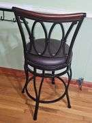 2 Black metal swivel bar stool with a dark brown cushioned seat.