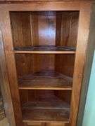 Wooden corner cabinet with display shelves and a lower storage cupboard