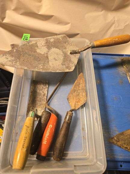 variety of used concrete and masonry hand tools.