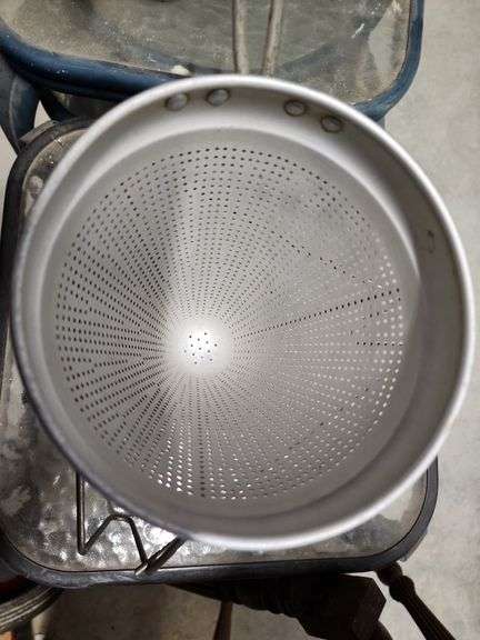 vintage aluminum cone strainer with a metal stand and wooden pestle