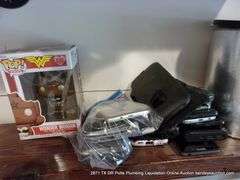 CONTENTS OF SHELF: BAGS, OLD PHONES, WONDER WOMAN FUNKO POP, CANDLES, PICTURE FRAMES