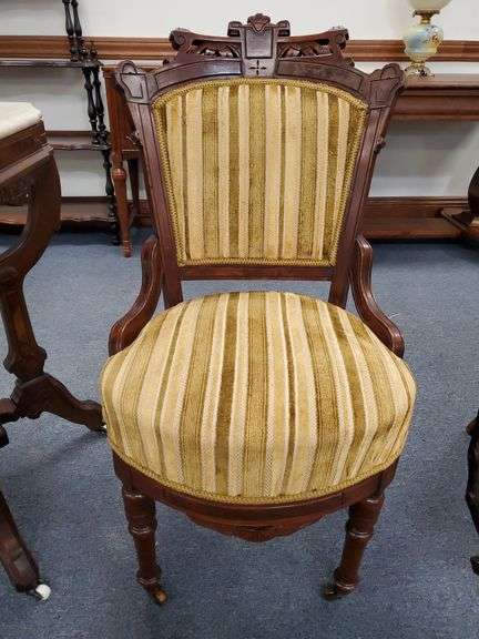 Antique Eastlake hip-hugger chair on castors.