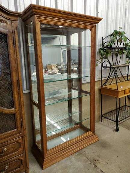 Solid oak curio / display cabinet features lights with mirrored back, four adjustable glass shelves, two side glass doors on each side, beveled edge glass on front. Measures 39 w x 16 in D inches x 80 H.