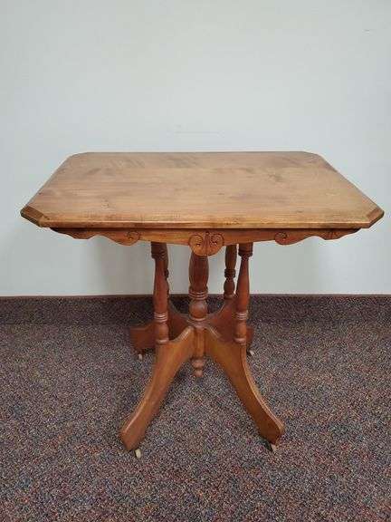 Vintage solid wood table with turned spindle accents and wood caster wheels. Measures 28 in W X 20 in DX 28 in H.