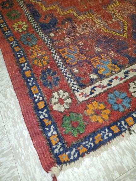 Hand knotted rug featuring center medallion and floral border. Measures 31-in x54 in.
