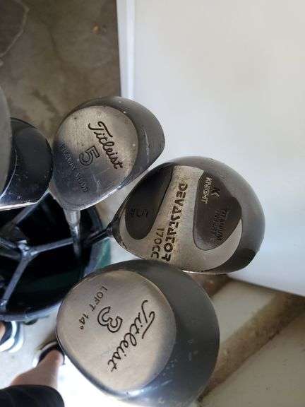 Spalding nylon golf bag with assorted drivers, sand wedge and putter. Includes two pairs of size 8 golf shoes by Ecco and FootJoy. See photos.