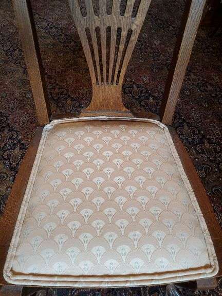 Vintage oak dining chair featuring paw feet, fan shaped pattern on upholstered seat, and slatted back design.