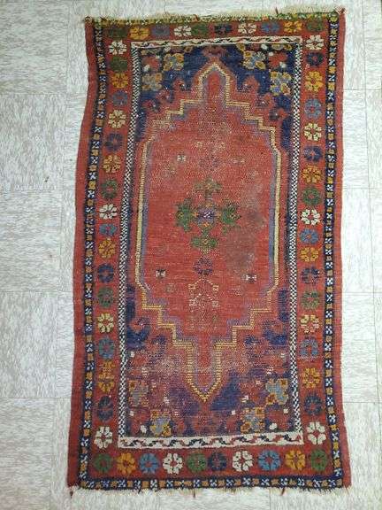 Hand knotted rug featuring center medallion and floral border. Measures 31-in x54 in.