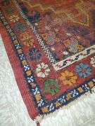 Hand knotted rug featuring center medallion and floral border. Measures 31-in x54 in.