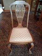 Vintage oak dining chair featuring paw feet, fan shaped pattern on upholstered seat, and slatted back design.